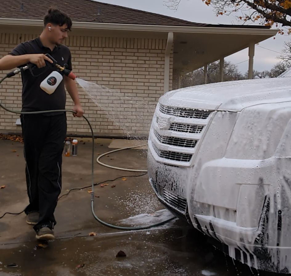 Mobile Prestige detailer foam-washing an SUV in a driveway